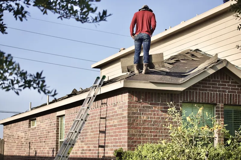 Professional roofer working on a residential roof in Van Hiseville